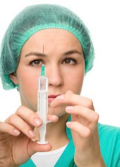 Image showing Young nurse is preparing syringe for injection