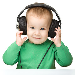 Image showing Cute boy enjoying music using headphones