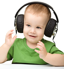 Image showing Cute boy enjoying music using headphones