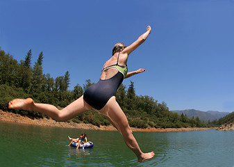 Image showing Young woman jumping in the lake