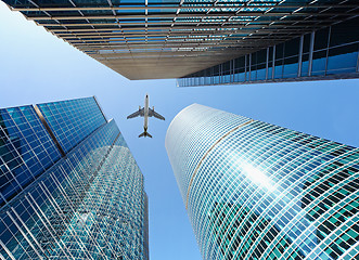 Image showing Airliner flying over skyscrapers