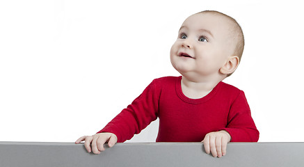 Image showing young child standing at grey cardboard