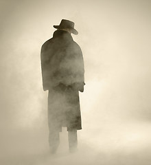 Image showing Woman wearing trench coat and standing in fog