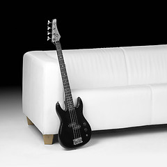 Image showing black bass guitar and white couch