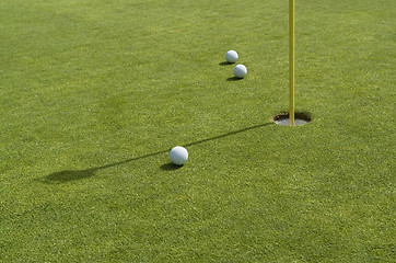 Image showing hole and golf balls in green back