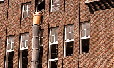 Image showing Exterior of an industrial building with a large brick wall