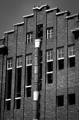 Image showing Exterior of an industrial building with a large brick wall