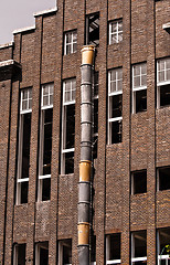 Image showing Exterior of an industrial building with a large brick wall