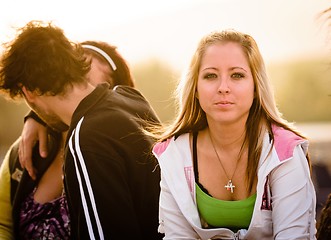 Image showing Proud girl with Young couple kissing in the background