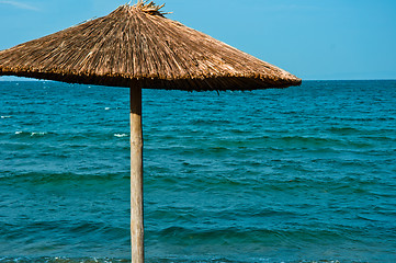 Image showing Umbrella against blue ocean 