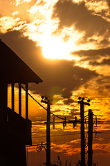 Image showing Silhouette of a high voltage post and a house