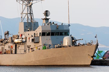 Image showing Big battle ship in the dock against blue sky and mountains