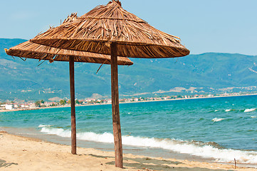 Image showing Umbrellas on the beach with mountan and ocean