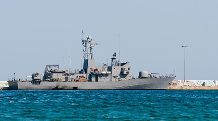 Image showing Big battle ship in the dock against blue sky and mountains