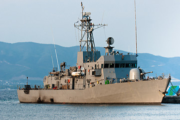 Image showing Big battle ship in the dock against blue sky and mountains