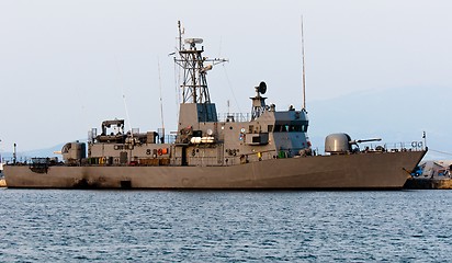 Image showing Big battle ship in the dock against blue sky and mountains