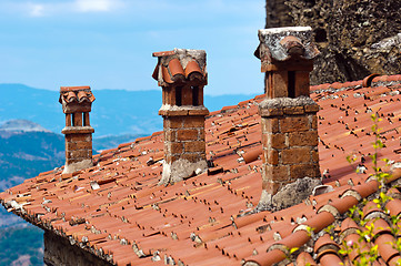 Image showing A rooftop with chimney against blue sky