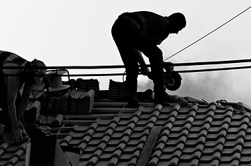 Image showing Industrial workers in hard work on the roof