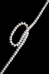 Image showing White pearls on the black silk 