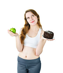 Image showing Young girl holding apple and cake