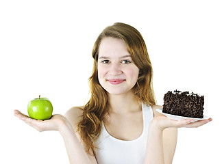 Image showing Young girl holding apple and cake