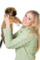 Image showing Young woman playing with a pekinese