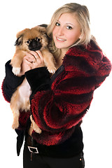Image showing Blond woman holding a pekinese puppy