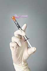 Image showing Syringe held by gloved hand