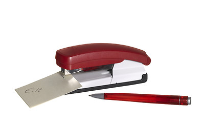 Image showing red stapler with paper and pen