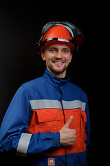 Image showing The worker in overalls and a helmet