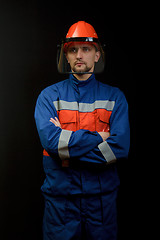 Image showing The worker in overalls and a helmet