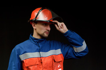 Image showing The worker in overalls and a helmet