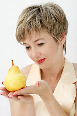 Image showing Funny girl holding a pear