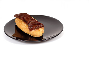 Image showing Chocolate eclair on black plate