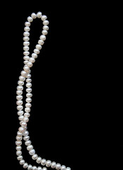 Image showing White pearls on the black silk