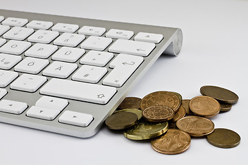 Image showing Computer keyboard with white keys and coins