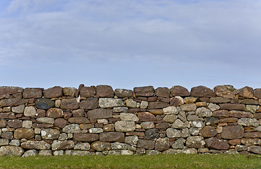 Image showing stone wall in evening light with grass and sky