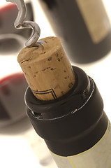 Image showing Corkscrew opening wine bottle 
