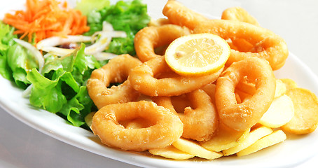 Image showing Deep batter fried squid rings calamari with green salad 