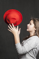 Image showing Girl is throwig a red hat