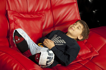 Image showing Kid on a red leather sofa