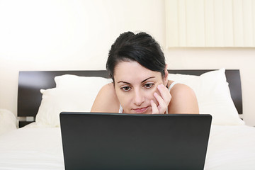 Image showing beautiful girl relaxing on the bed with her laptop