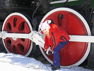 Image showing girl and wheels of old locomotive