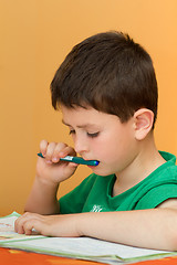 Image showing boy doing homework from school in workbook