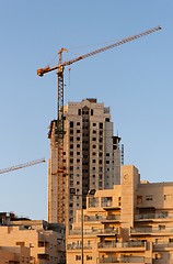 Image showing Lifting crane and building under construction at sunset