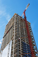 Image showing Lifting crane and high building under construction 