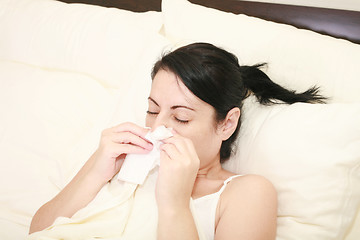 Image showing Closeup of gorgeous caucasian woman with cold sneezing into tissue over white background