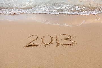 Image showing 2013 written in sand with waves