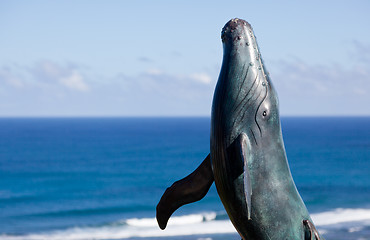 Image showing Statue of whale breaching with sea