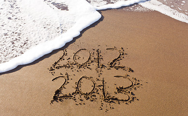 Image showing 2012 and 2013 written in sand with waves